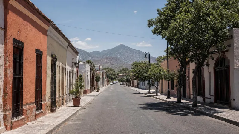 Sunny June street near Linares historic center with Sierra Madre foothills beyond Nuevo Leon rooftops
