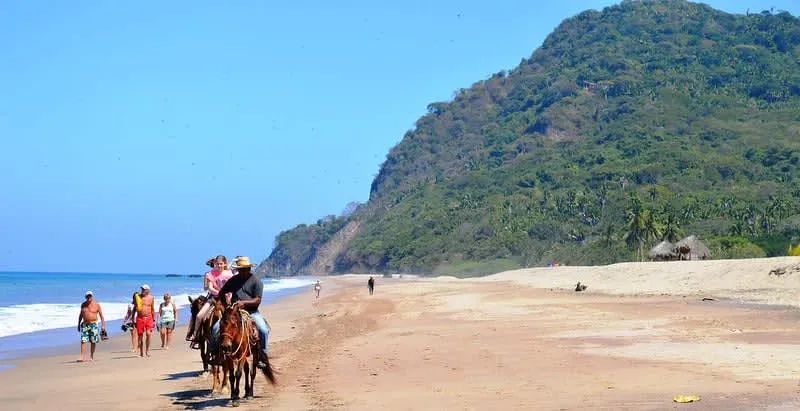 Wide Lo de Marcos shoreline with fishing boats and beach houses near the sand