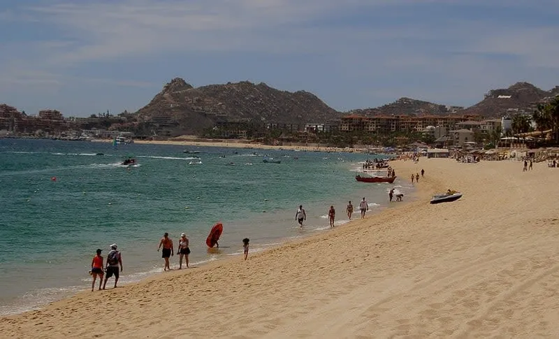 Medano Beach in Los Cabos with clear water and El Arco visible in the distance