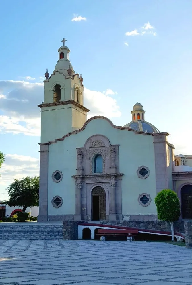 White bell tower of the Templo de Santa Maria Magdalena beside the plaza