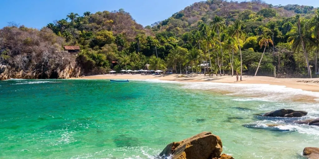 Majahuitas cove with jungle-covered hills and calm turquoise water