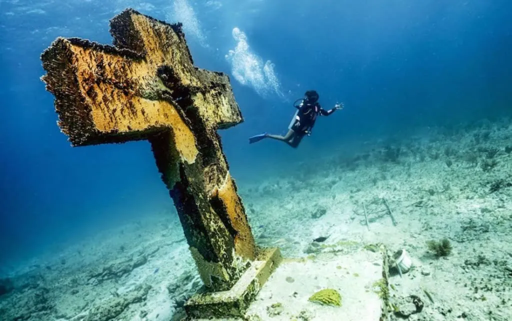 Diver over coral and clear blue water at Manchones Reef near Isla Mujeres