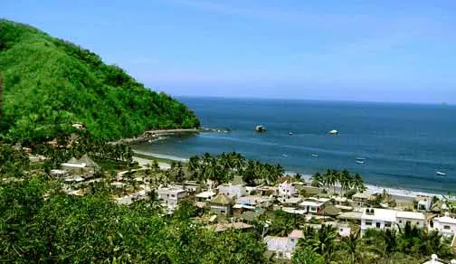 La Manzanilla village on the Jalisco coast — palm-lined beach at the edge of a lagoon where wild crocodiles are frequently spotted