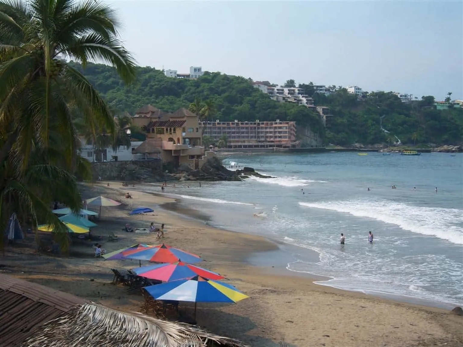 Santiago Bay in Manzanillo with calm Pacific water, palm shade, and clear December light