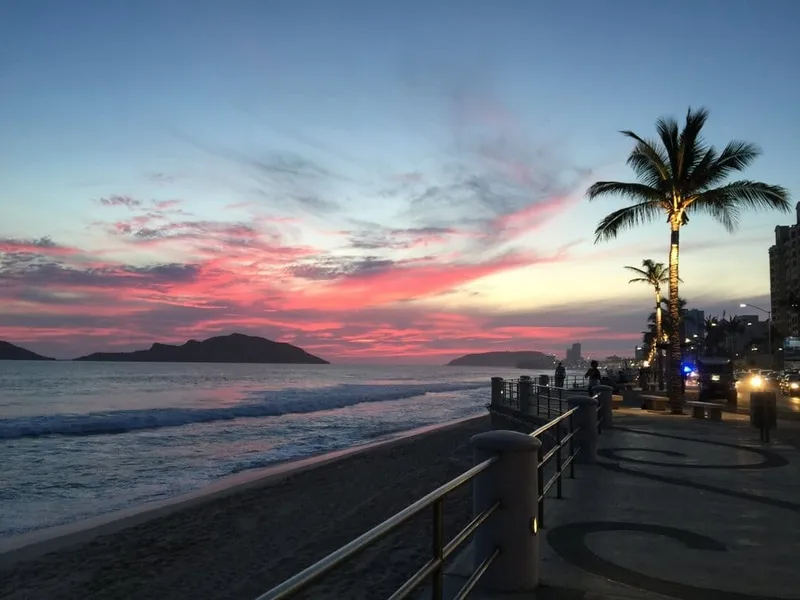 Street vendor selling smoked marlin tacos in Mazatlán with corn tortillas and fresh toppings near the fishing district