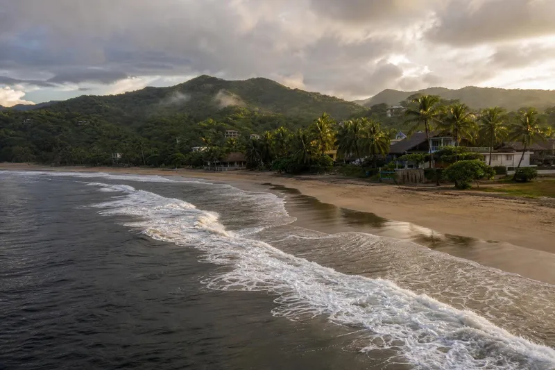 Mazunte beach and green Oaxaca Coast hills during October shoulder-season weather