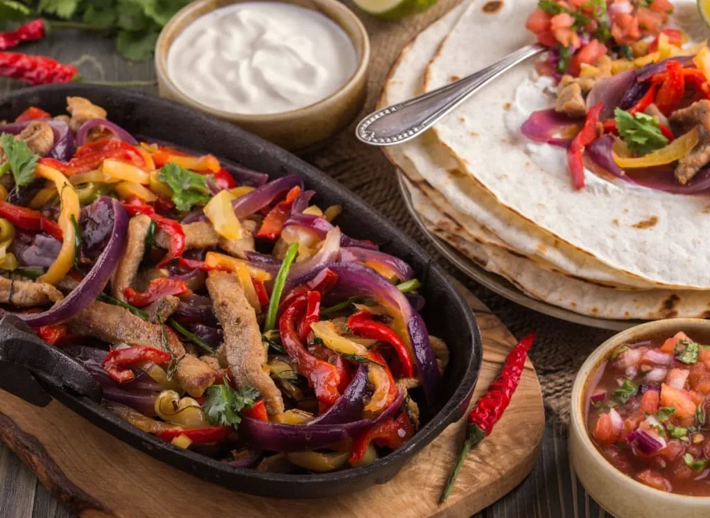 Sizzling fajitas with peppers, onions, and warm tortillas