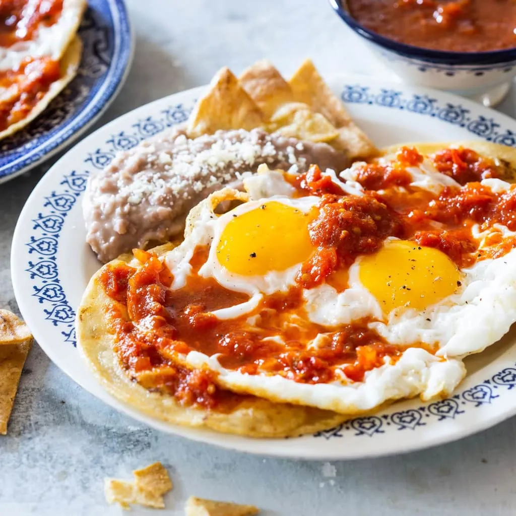 Huevos rancheros with fried eggs, tortillas, beans, and salsa