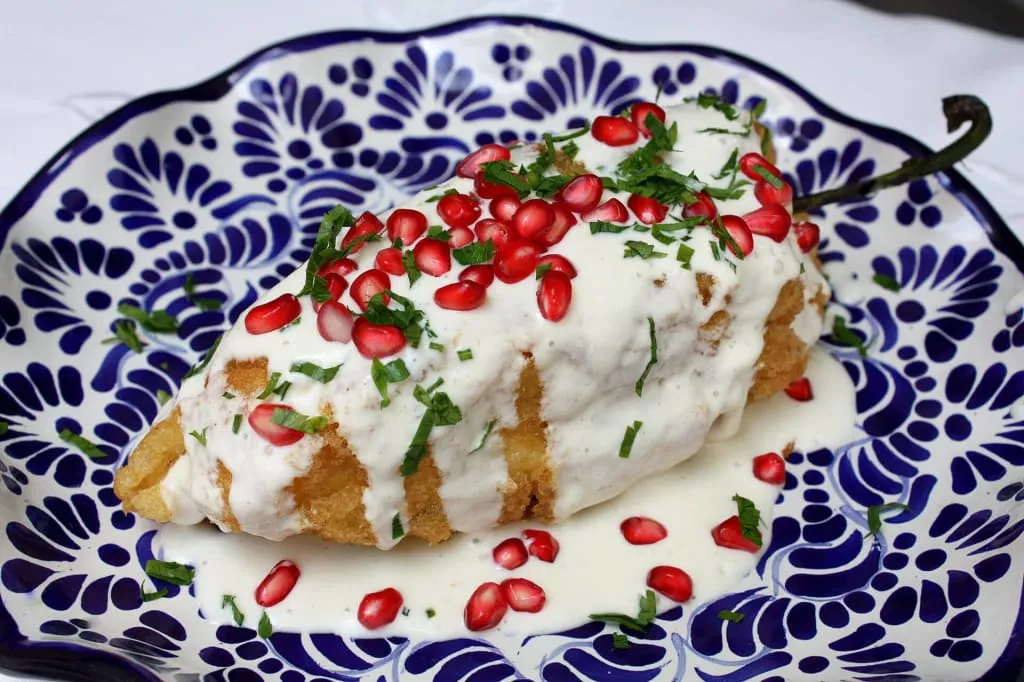 Chiles en nogada with walnut sauce, pomegranate, and parsley