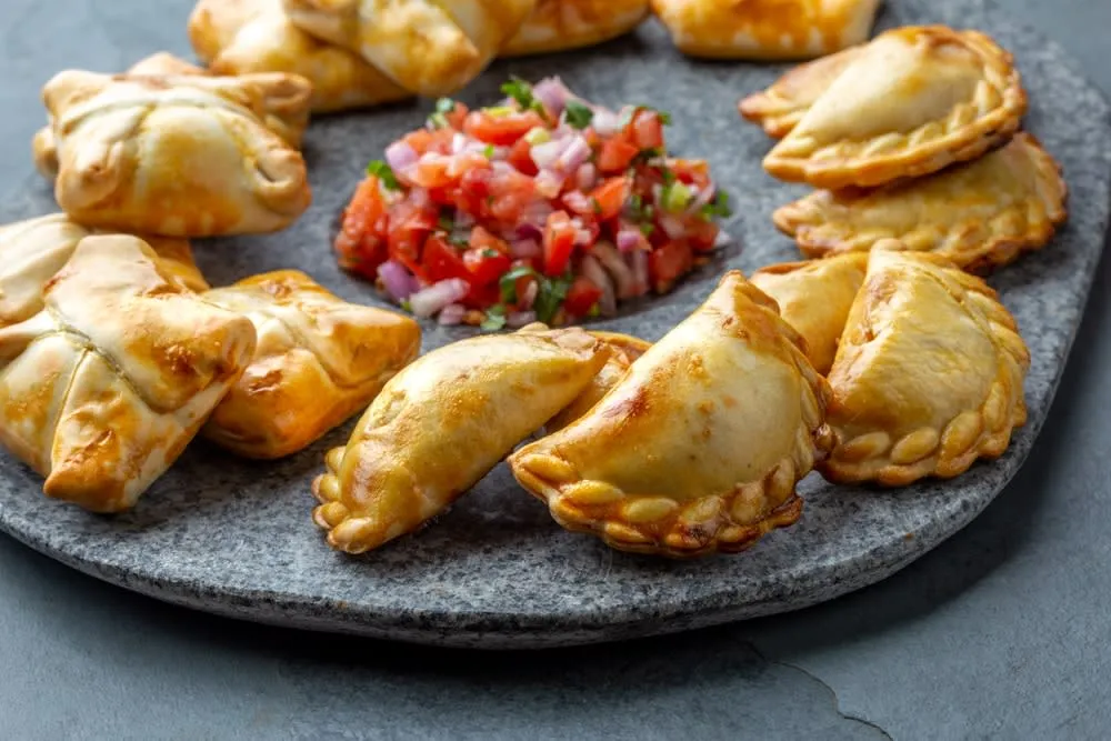Golden Mexican empanadas served with salsa and fresh toppings