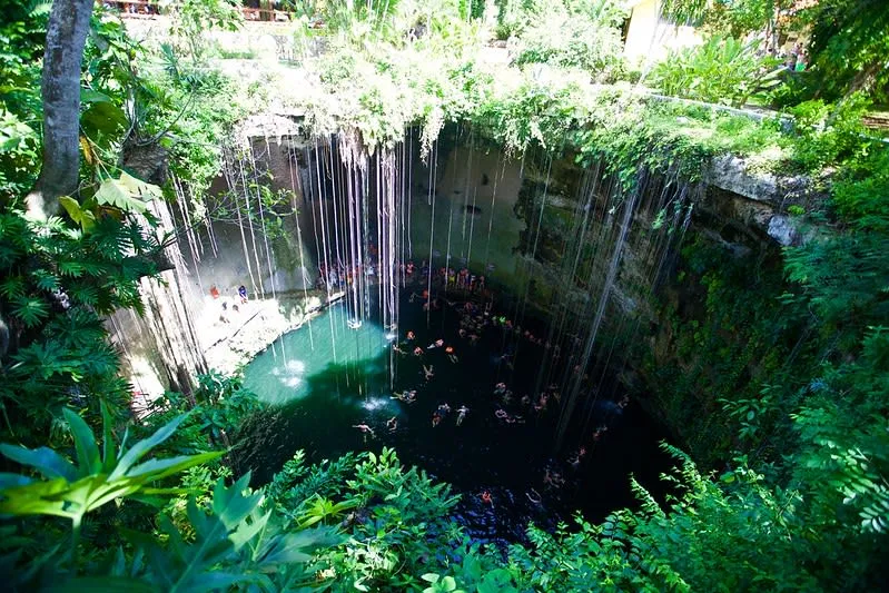 Cenote Ik Kil near Chichen Itza — circular open pit with hanging vines cascading into turquoise water