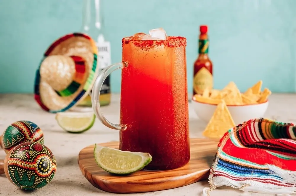 Frosted michelada glass with lime and spicy seasoning