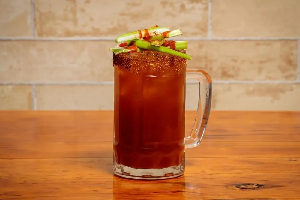 Clamato michelada with dark beer in a salt-rimmed glass