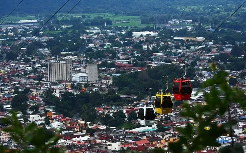 Teleferico de Orizaba gondolas crossing above the city toward Cerro del Borrego
