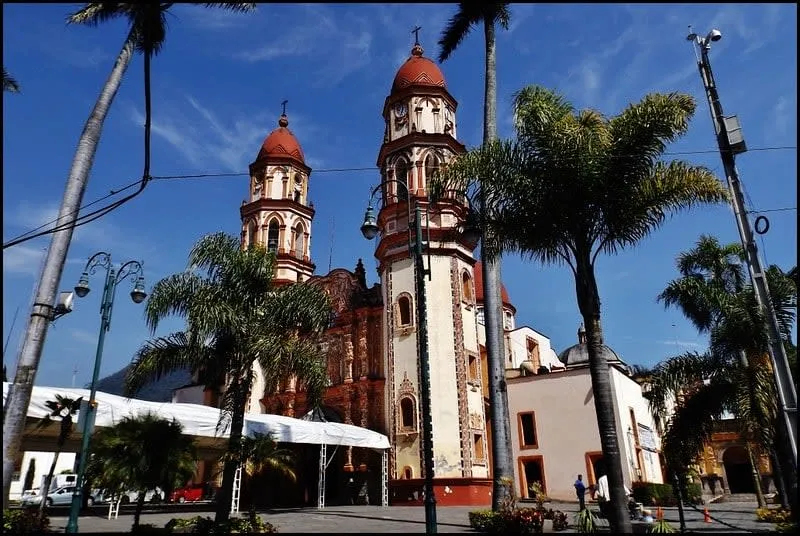 Street view in Orizaba with colorful buildings and green hills behind town