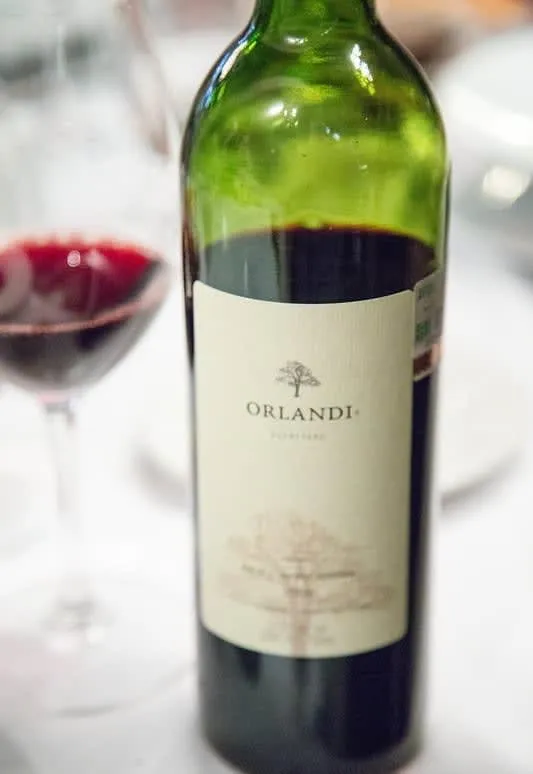 Red wine bottle with glass in background