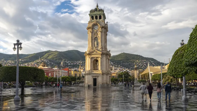 Pachuca clock tower and central plaza during July rainy-season weather in Hidalgo
