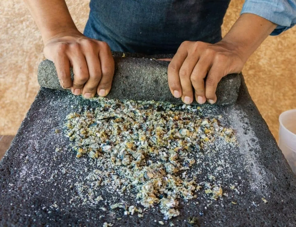 Roasted corn kernels spread across a hot comal before grinding