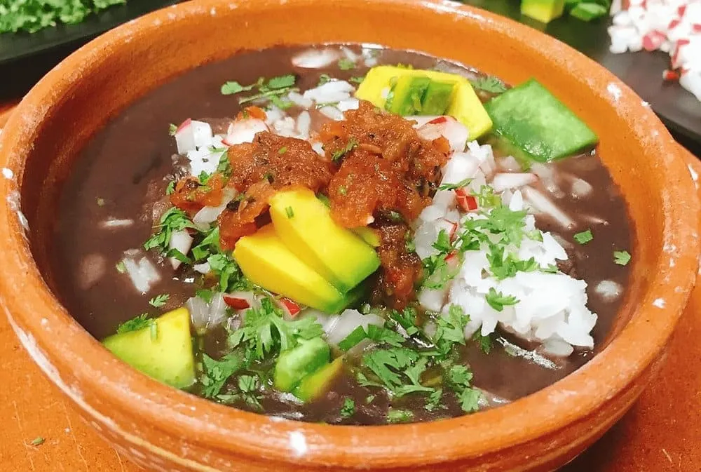 Frijol con puerco — black beans with pork served with radishes, cilantro, and habanero salsa in Yucatan