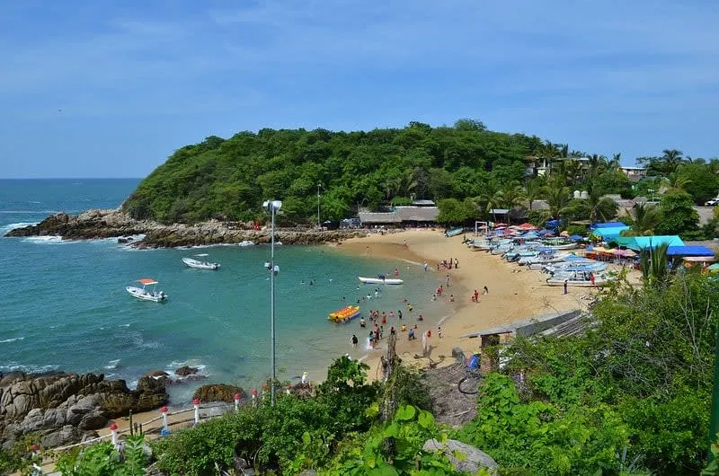 Puerto Angelito cove with calm turquoise water and palapas