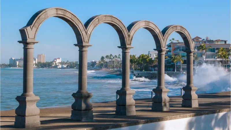 Los Muertos Beach in Puerto Vallarta with gentle waves and green hills in the distance