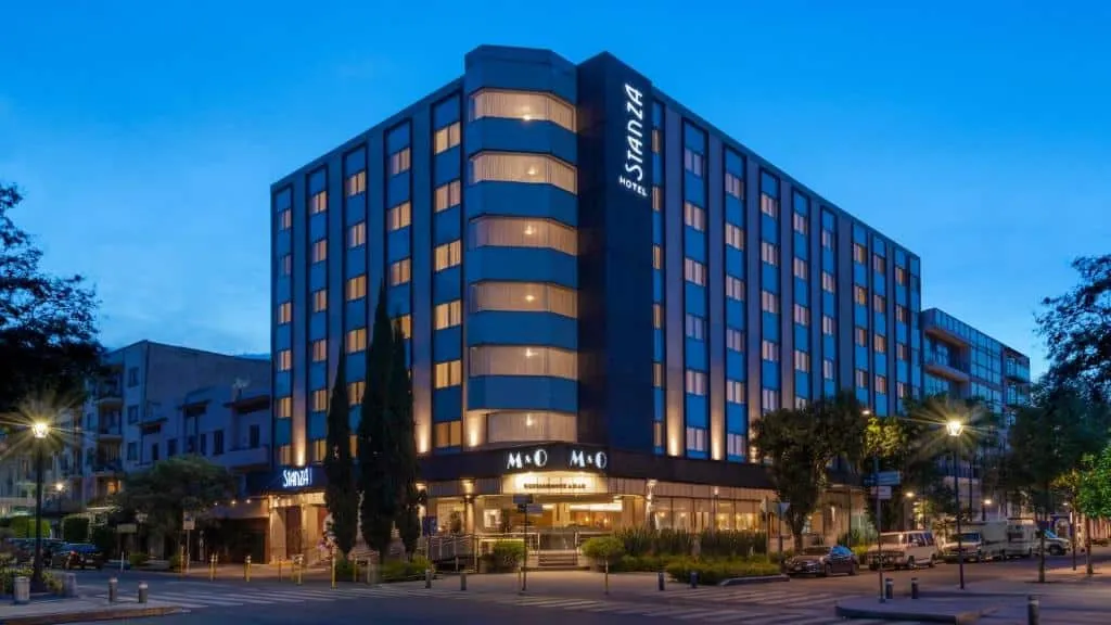 Stanza Hotel guest room with neutral decor and wide windows
