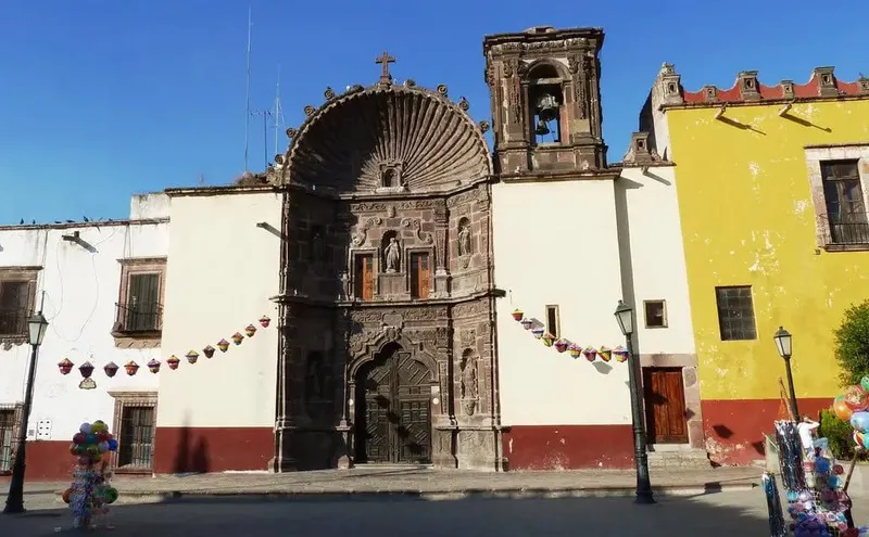 La Parroquia de San Miguel Arcángel pink neo-Gothic church facade with twin towers against blue sky in San Miguel de Allende