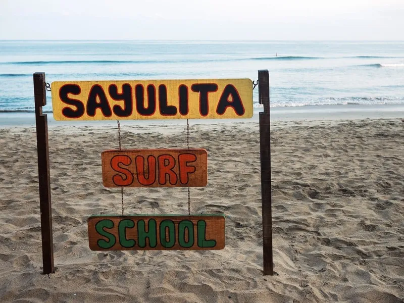 Orange sunset over Sayulita beach with people gathered near the shoreline