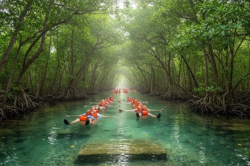 Visitors floating down an ancient Maya canal through mangrove tunnels inside Sian Ka'an UNESCO biosphere reserve south of Tulum