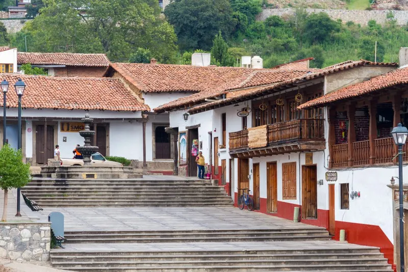 Tapalpa Jalisco historic center with cobblestone street, colonial white buildings with tile roofs, and church facade