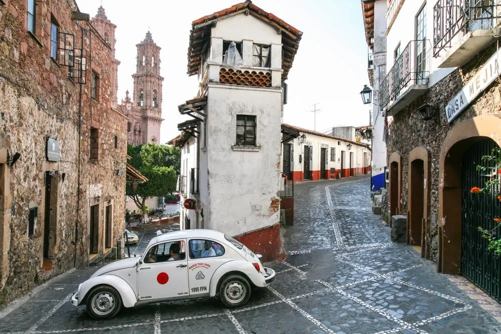 Aerial view of Taxco Mexico showing the white colonial city built on the mountain hillside with Santa Prisca church