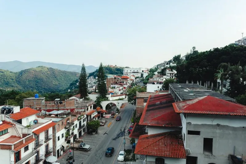 White Taxco homes climbing the hillside around Santa Prisca church on a clear mountain day