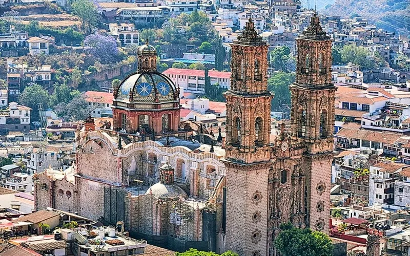 Santa Prisca church rising above white Taxco houses and steep mountain streets