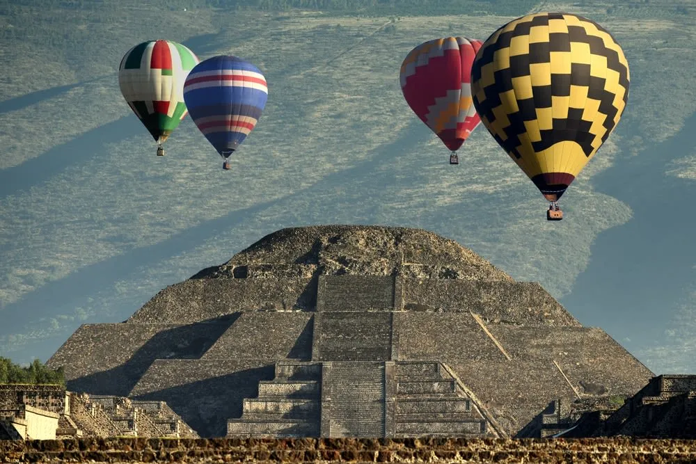 hot air balloons over Teotihuacan pyramids at sunrise viewed from the archaeological zone