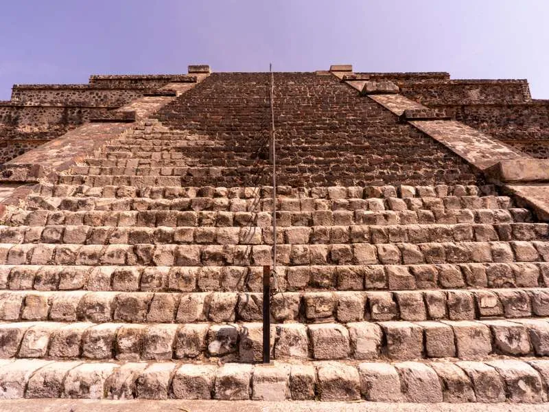 Teotihuacan Pyramid of the Sun at sunrise with the Avenue of the Dead stretching toward the smaller Pyramid of the Moon