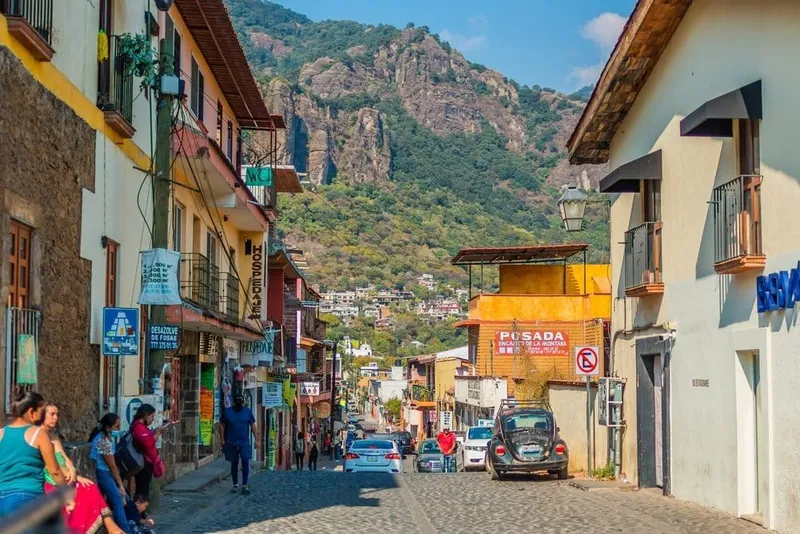 Steep green cliffs and rooftops around Tepoztlán after the first summer rains