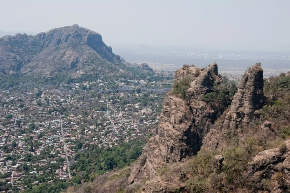 Tepozteco pyramid above Tepoztlán Morelos Mexico on the volcanic cliff face with colonial church and village below