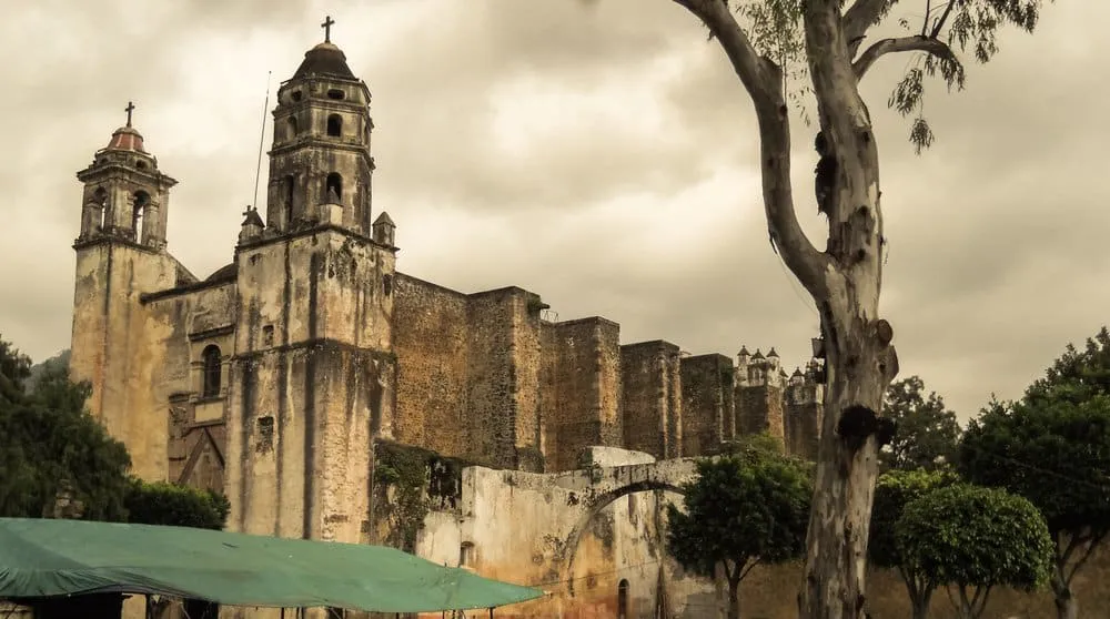 Colorful Sunday tianguis market stalls in Tepoztlán selling handcrafted ceramics, textiles, mezcal, and organic produce along the main avenue