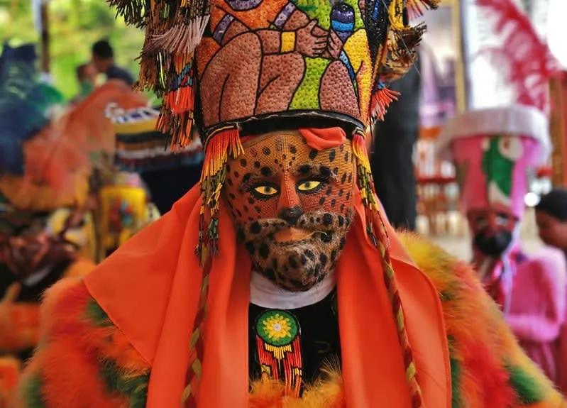 Chinelos dancers in their elaborate feathered headdresses and embroidered velvet robes performing at a Tepoztlán Carnival celebration