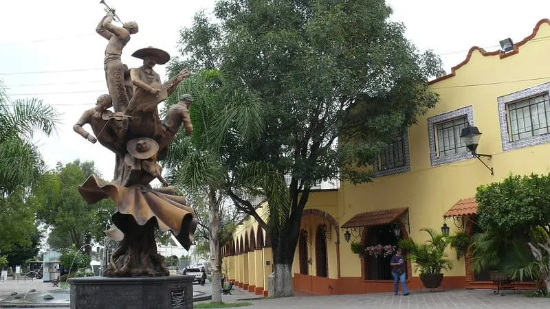 Main square in Tlaquepaque with trees, benches, and colonial facades