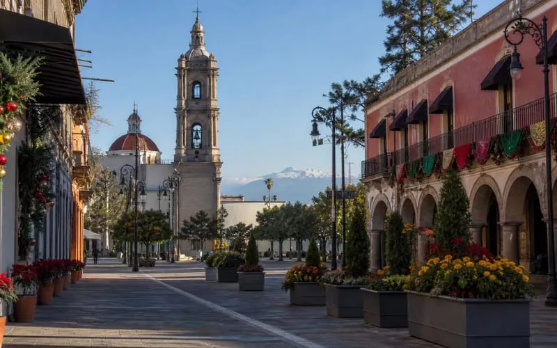 Toluca plaza in December with Christmas decorations, clear highland light, and Nevado de Toluca in the distance
