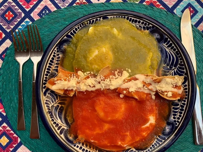 Huevos divorciados with red and green salsa separated by refried beans