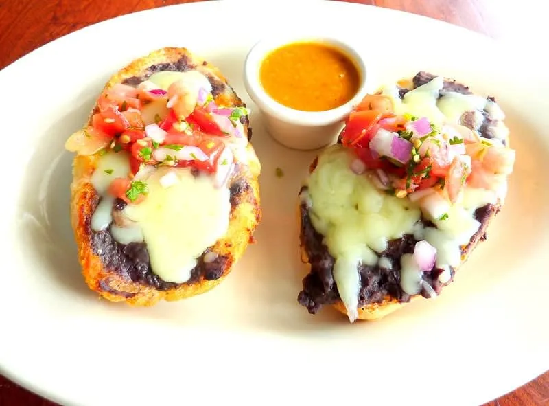 Molletes with refried beans, melted cheese, and pico de gallo