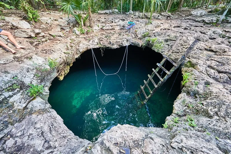Cenote Calavera near Tulum Mexico — crystal-clear turquoise water in a natural limestone sinkhole with rope swings