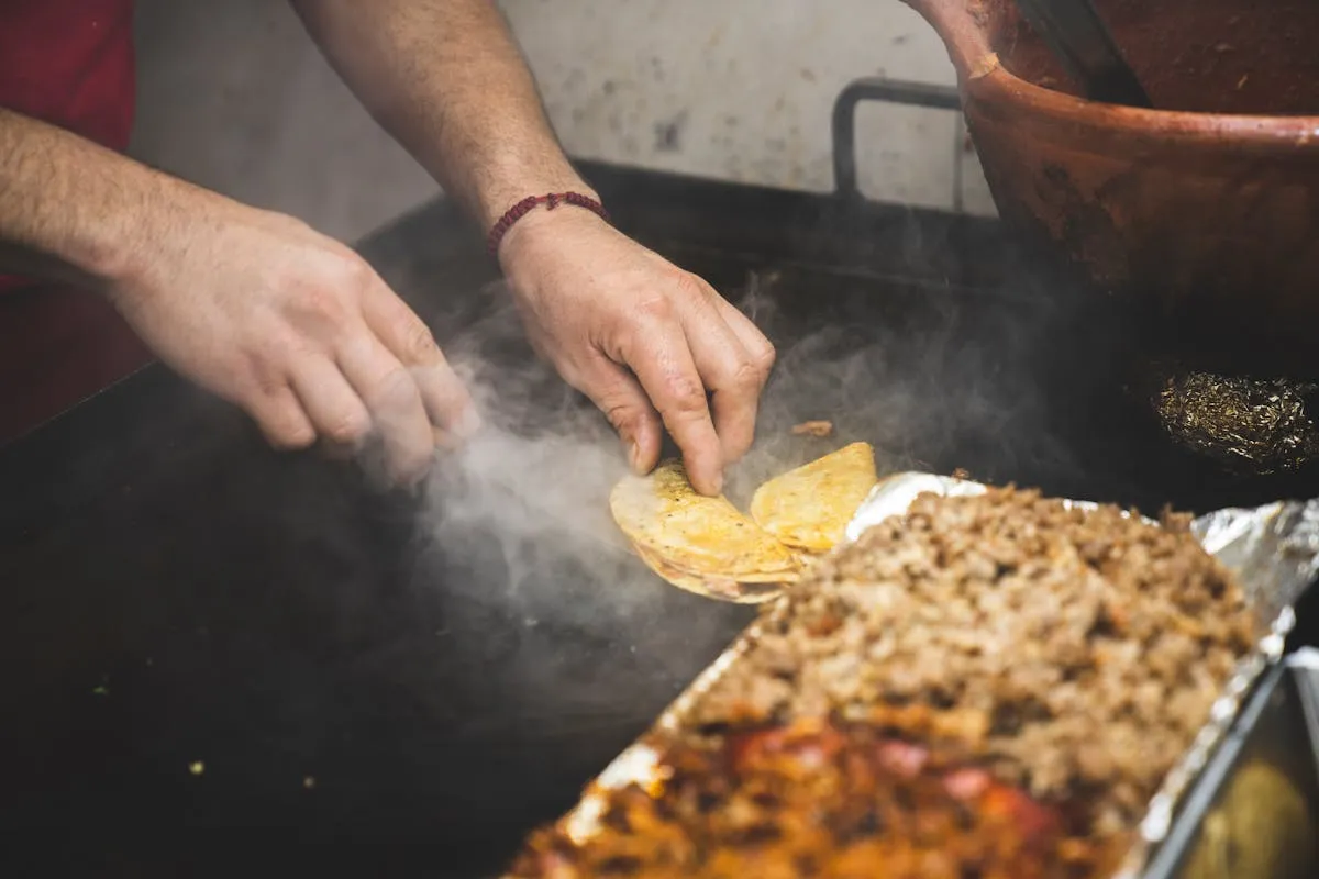 Street food vendor preparing Mexican tacos at a Tulum town market in Quintana Roo, Mexico