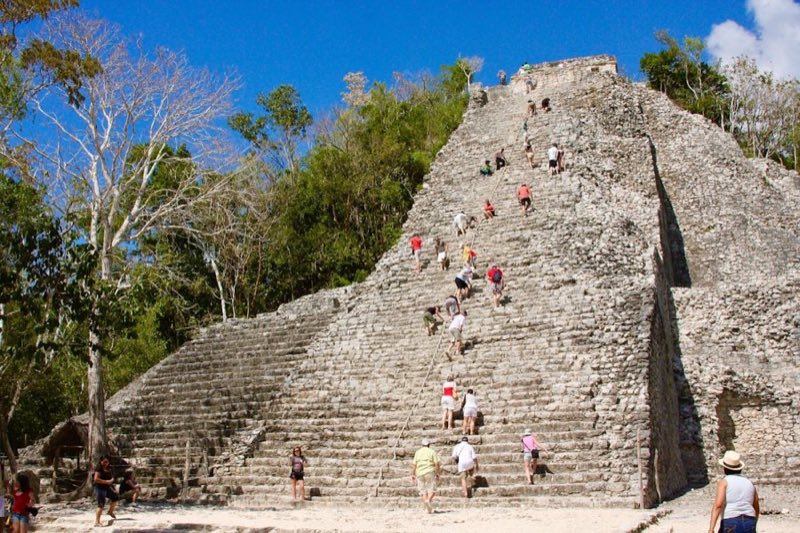 Tourists climbing the rope-assisted steps of Nohoch Mul pyramid at Cobá — the main reason travelers make the trip from Cancun