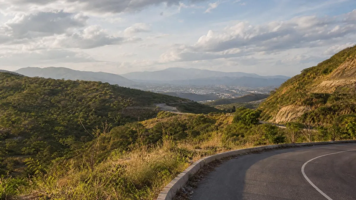 Road through green lowland hills near Tuxtla Gutierrez in November after the rainy season