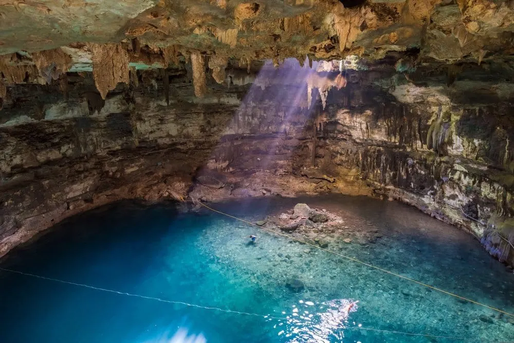 Cenote Suytun cave cenote with stone walkway and light beam, near Valladolid Yucatán