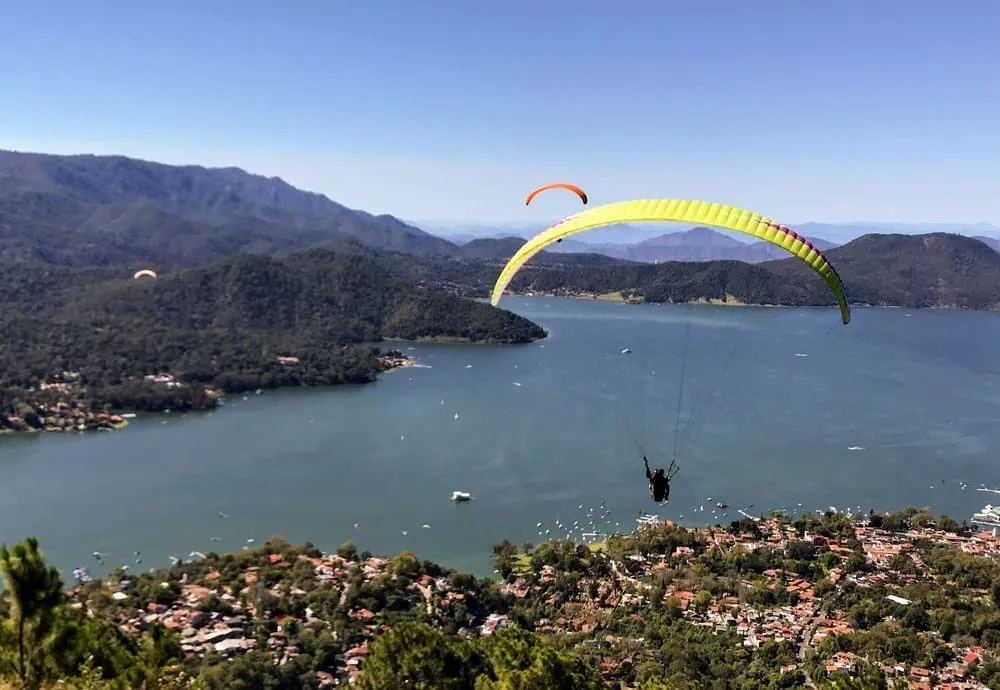 Valle de Bravo lake town in Mexico State with boats on the reservoir and white colonial buildings on the hillside