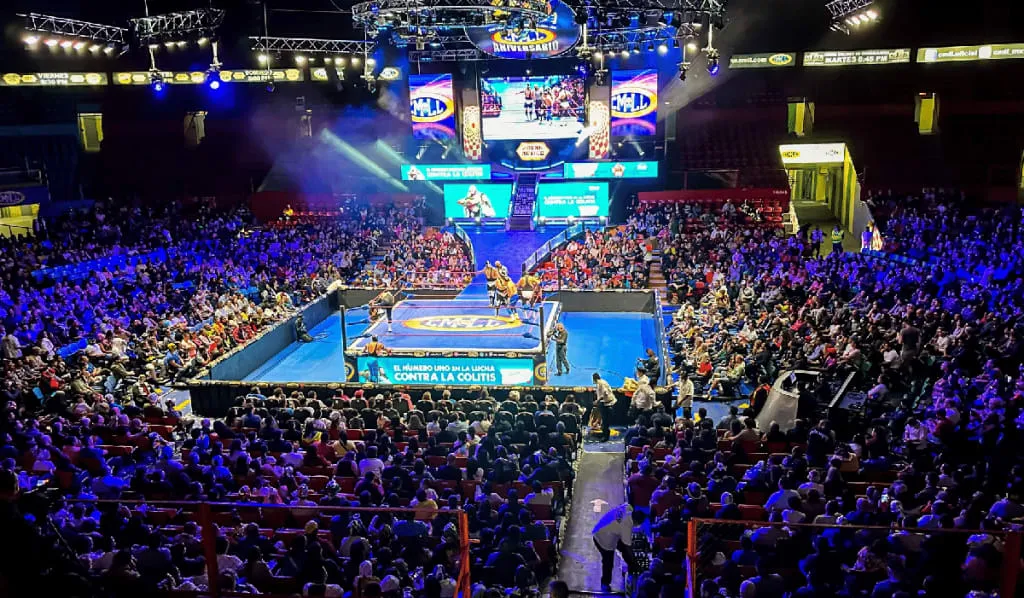 Masked wrestlers face off inside Arena Mexico during a lucha libre match